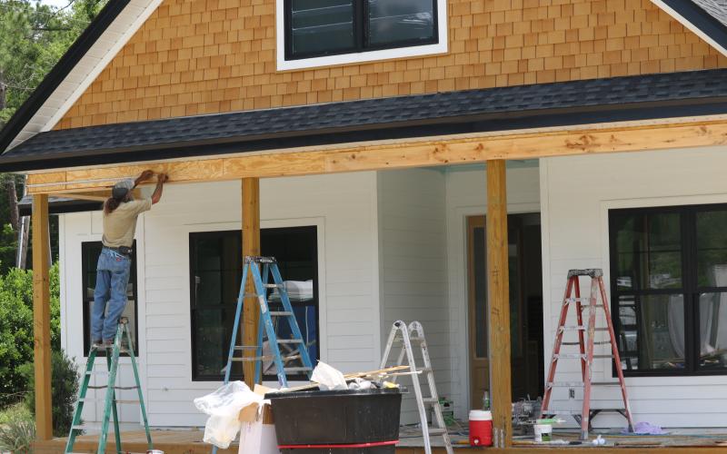 A worker with Stanley Crawford Construction works on the front of a house in the Hickory Cove neighborhood on Friday. The home will be part of the Parade of Homes this weekend. (JAMIE WACHTER/Lake City Reporter)