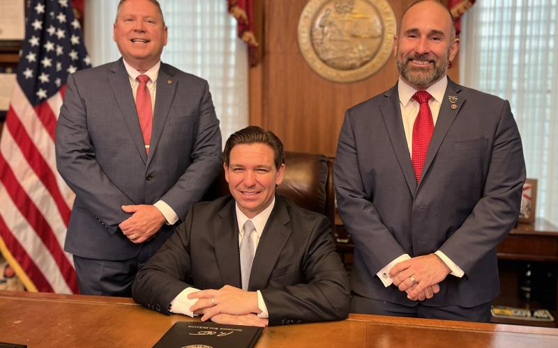 House bill sponsor Chuck Brannan (from left), Gov. Ron DeSantis and Senate bill sponsor Jay Collins pose at Monday’s bill signing event. (COURTESY)