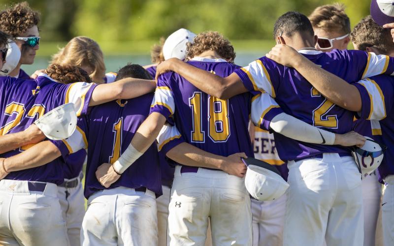 Columbia teammates huddle before a game against on March 24. (ALAN YOUNGBLOOD/Special to the Reporter)