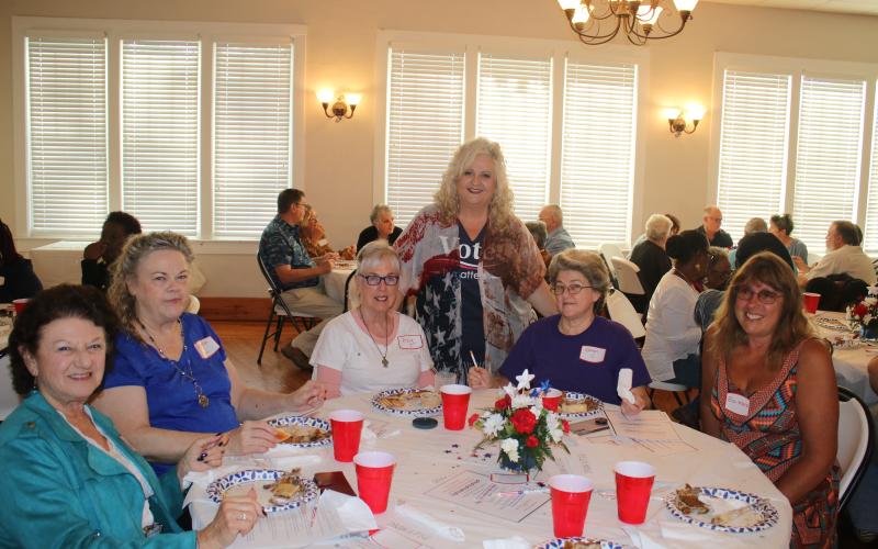 Columbia County Supervisor of Elections Tomi Brown (standing) makes the rounds at a dinner honoring election workers. (TONY BRITT/Lake City Reporter)