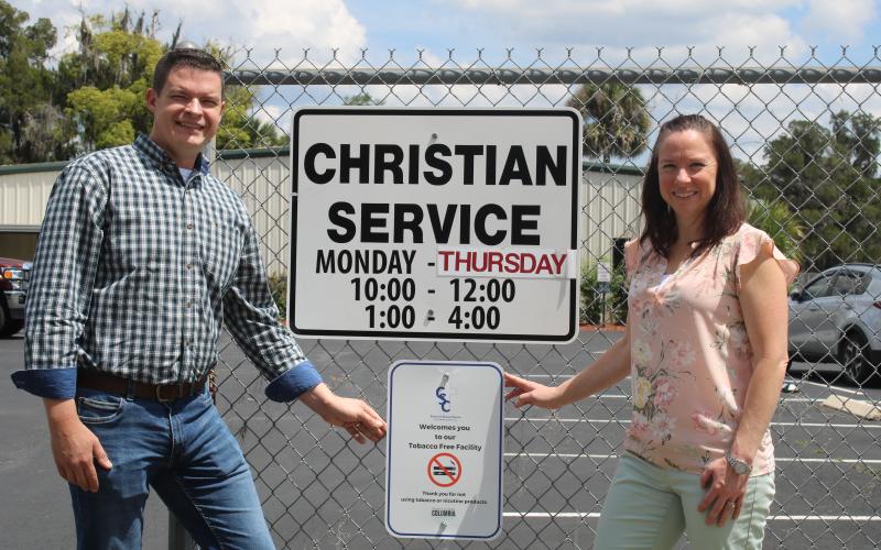 Chris Walters (left) and Brooke Frye show off the Christian Service Center’s new tobacco-free sign hanging in front of the center. (TONY BRITT/Lake City Reporter)