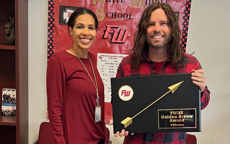 Nicole Bailey (from left), a Fort White High School assistant principal, presents Justin Jenkins, an eighth-grade science teacher, with the school’s inaugural Golden Arrow Award. The award is designed to recognize and honor any staff member that goes above and beyond their traditional job duties. (COURTESY)