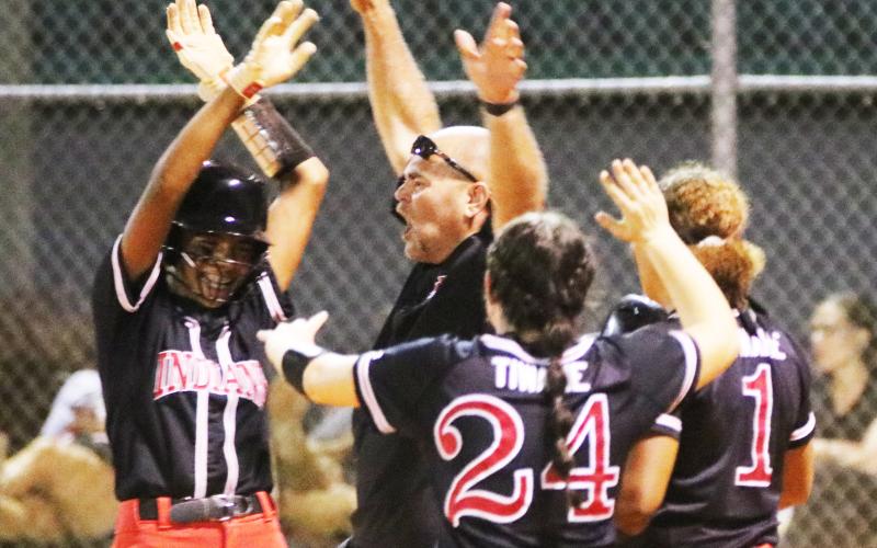 Fort White catcher Morgan (left) celebrates with coach Chad Padgett (middle) and pitcher Kadence Compton (24) after hitting a walk-off RBI single to defeat Baldwin on Thursday night. (JORDAN KROEGER/Lake City Reporter)
