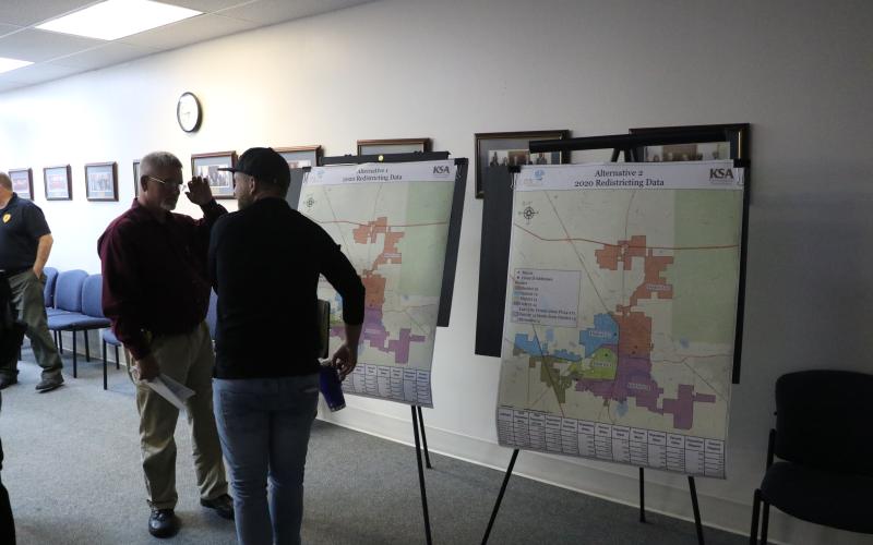 Lake City Assistant Police Chief Andy Miles (left) looks over the proposed redistricting maps with Joshua Garner after the Lake City Council’s workshop Tuesday. (MORGAN MCMULLEN/Lake City Reporter)