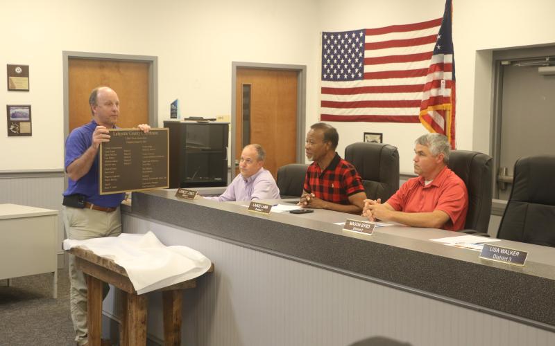 Will Rutherford with Clemons Rutherford &amp; Associates presents the Lafayette County Commission with a plaque commemorating the Lafayette County Courthouse renovations. County Clerk Steve Land (second from left), Chairman Earnest Jones and Commissioner Lance Lamb look on. (MORGAN MCMULLEN/Lake City Reporter)