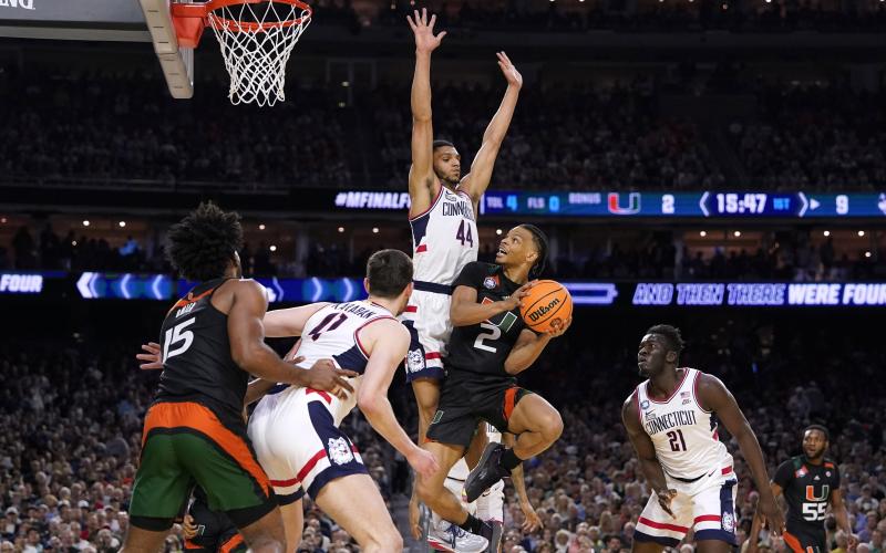 Miami guard Isaiah Wong (2) drives to the basket against Connecticut guard Andre Jackson Jr. (44) during the Final Four on Saturday in Houston. (DAVID J. PHILLIP/Associated Press)