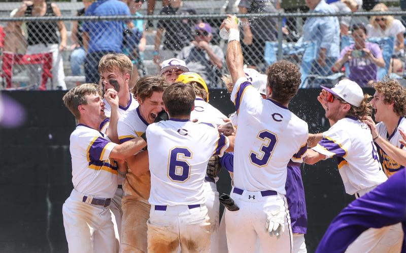 Columbia players swarm Josh Fernald at home plate after Fernald hit a walk-off grand slam against Lincoln on Saturday in the Region 1-5A semifinals. The Tigers won 8-4. (BRENT KUYKENDALL/Lake City Reporter)