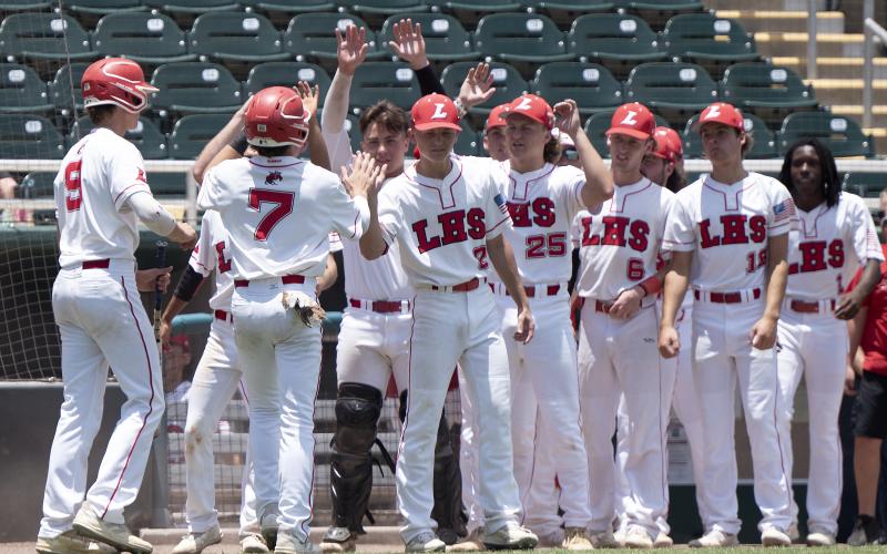 Lafayette’s Garrett Taylor (9) and Baylor Johnson (7) are greeted by teammates after scoring against Holmes County during the Class 1A state semifinals on Wednesday at Hammond Stadium in Fort Myers. (CHRIS TILLEY/Special to the Reporter)