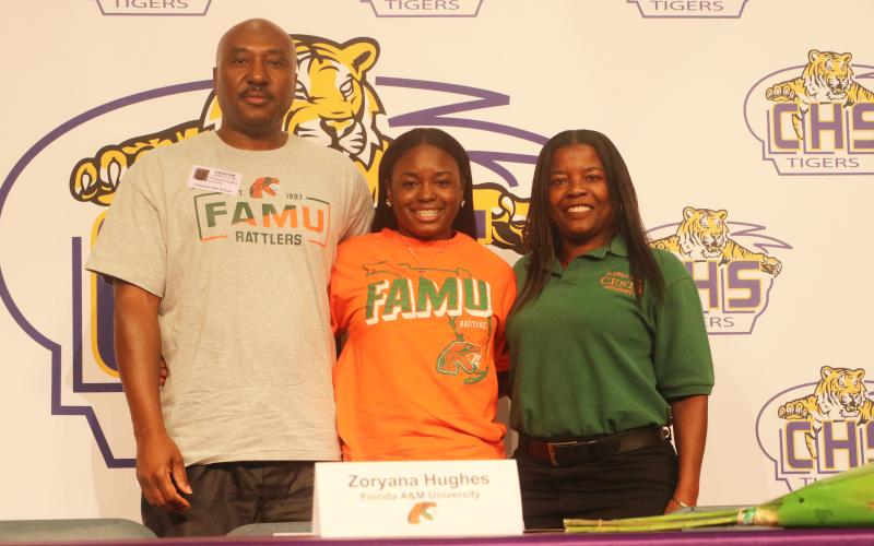 Columbia pitcher Zoryana Hughes (middle), picture alongside her father, Chris Hughes, and her mother, Sally Russell, signed her letter of intent to play at Florida A&amp;M on Wednesday. (JORDAN KROEGER/Lake City Reporter)