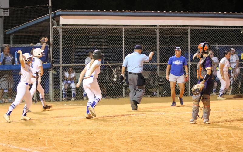 Deltona's Sophie Stempel, Christina Ortiz and Emily Donohue celebrate after scoring three runs while Columbia catcher Emily Delgado looks on during Thursday's Region 1-5A quarterfinal. (JORDAN KROEGER/Lake City Reporter)