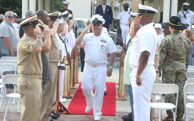 U.S. Navy Master Chief Damage Controlman Robert Ratliff salutes fellow service members as he “comes ashore” during his retirement ceremony Friday. (MORGAN MCMULLEN/Lake City Reporter)