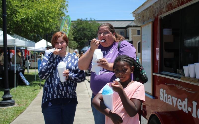 Hannah Hunter (from left), Jessica Frame and Kaleah Shead enjoy their cups of shaved ice while attending the Spring Market in Olustee Park in May 2021. (FILE)