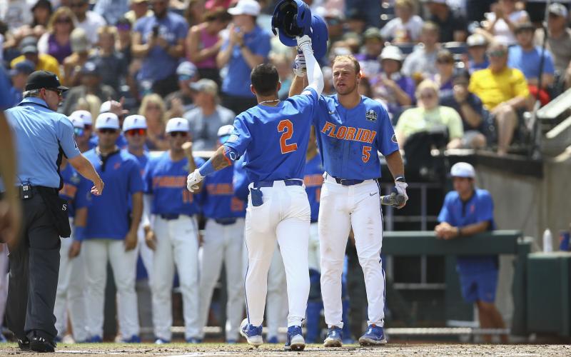 Florida outfielder Ty Evans (2) is greeted at the plate by Ben Nippolt (5) after his solo home run during the second inning of Game 2 of the College World Series finals against LSU on Sunday in Omaha, Neb. (JOHN PETERSON/Associated Press)