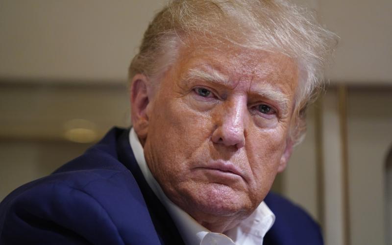 Former President Donald Trump listens as he speaks with reporters while in flight on his plane after a campaign rally at Waco Regional Airport on March 25 in Waco, Texas. (EVAN VUCCI/AP File)