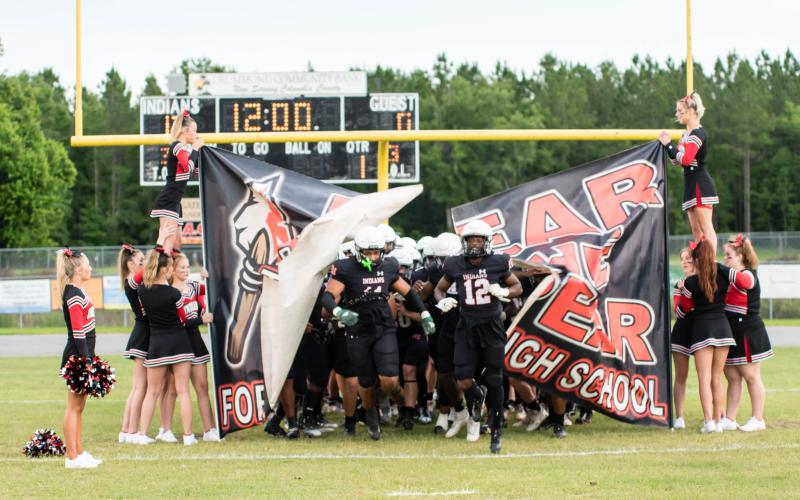 Fort White linebacker Lecosta Byrd (left) and receiver Najeeb Smith (right) lead the Indians on to the field for their spring game on May 23. (CHRISTINA FEAGIN/Special to the Reporter)