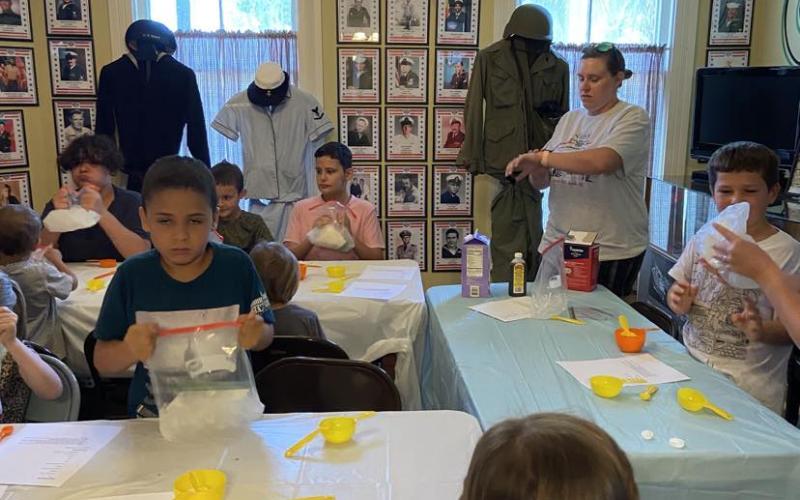 Landon Ream, left, is among the children that learned how to make ice cream in a bag Thursday at the Lake City-Columbia County Historical Museum. (COURTESY)