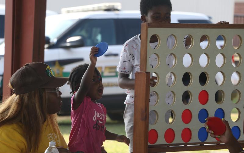 Tylie Davis looks to make a play during a ‘Connect 4’ game with Tyrice Baynard as Katie McGowan looks on Friday during the Summer Nights program at Melrose Park Elementary School. (MORGAN MCMULLEN/Lake City Reporter)