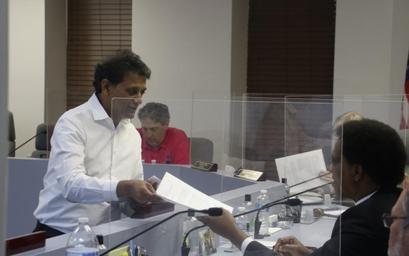 Nick Patel hands out information to the Lake City Council at Monday’s meeting about the proposed Circle K expansion. (MORGAN MCMULLEN/Lake City Reporter)