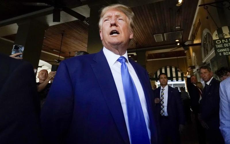 Former President Donald Trump visits Café du Monde in New Orleans on Tuesday. Trump received a new charge Thursday in the Mar-a-Lago investigation. (GERALD HERBERT/Associated Press)