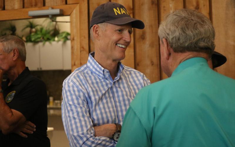 Sen. Rick Scott smiles as he talks with Hamilton County Sheriff Harrell Reid during a visit to the Nutrien Conference Center in White Springs on Thursday. (JAMIE WACHTER/Lake City Reporter)