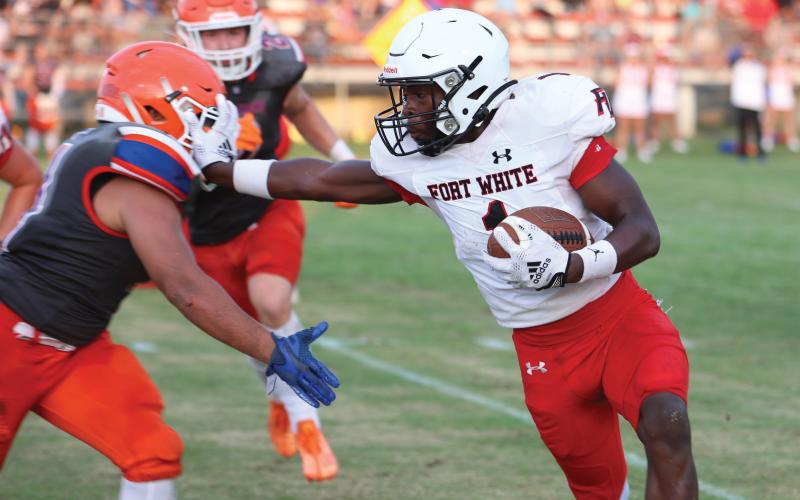 Fort White running back Dakota Fisher stiff arms a Branford defender during Friday night’s three-team jamboree at Trenton. (PAUL BUCHANAN/Special to the Reporter)