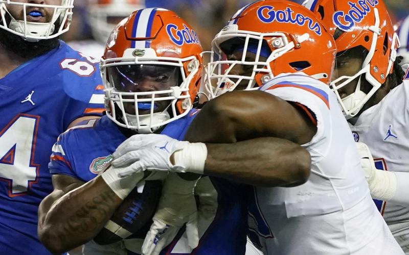 Florida running back Cam Carroll (left) is tackled by Florida edge Kelby Collins during the team's annual Orange and Blue spring game on April 13 in Gainesville. (JOHN RAOUX/Associated Press)