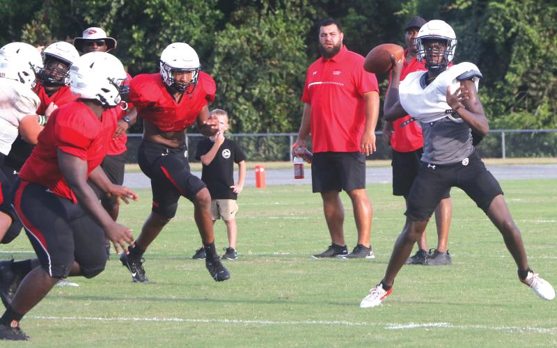 Fort White quarterback Jayden Jackson rolls out to throw a pass during Friday’s team scrimmage. (MORGAN MCMULLEN/Lake City Reporter)