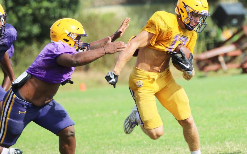 Columbia receiver Camdon Frier runs up the field after a catch as linebacker Wilson Philemon gives chase during Friday’s scrimmage. (JORDAN KROEGER/Lake City Reporter)