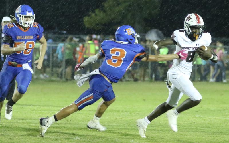 Fort White quarterback Jayden Jackson scrambles to evade a tackle by Taylor County defensive back Baylor Johnson on Friday night. (MORGAN MCMULLEN/Lake City Reporter)