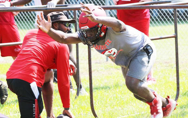 Lafayette defensive end Amarie Fleming performs a drill with head coach Marcus Edwards during Tuesday’s practice. (JAMIE WACHTER/Lake City Reporter)
