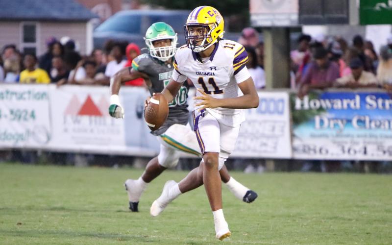 Columbia quarterback Zack Paulk scrambles away from Suwannee defensive end Ja’Darius Cherry during Friday’s Preseason Classic. (BRENT KUYKENDALL/Lake City Reporter)