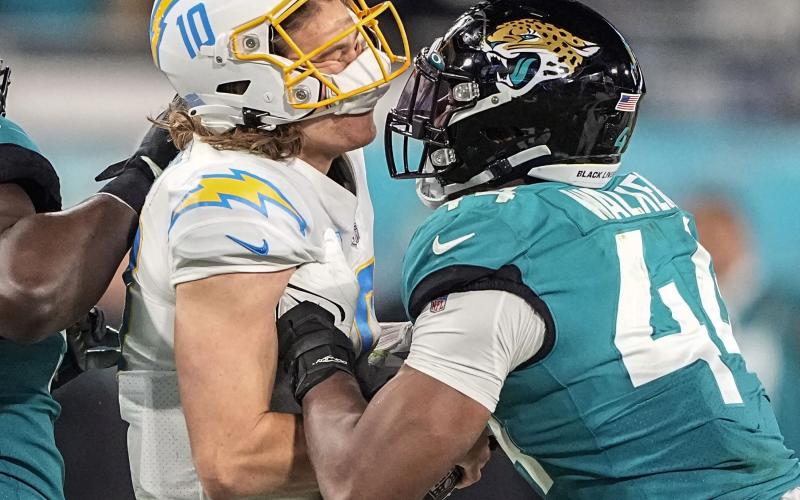Los Angeles Chargers quarterback Justin Herbert is hit by Jacksonville Jaguars linebacker Travon Walker during their wild-card playoff game on Jan. 14 in Jacksonville. (CHRIS CARLSON/AP File)