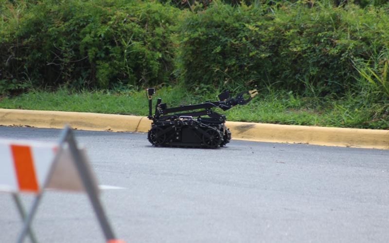 A robot drives down the driveway to the Quality Inn after entering to view the suspicious device left in a room at the hotel. (JAMIE WACHTER/Lake City Reporter)