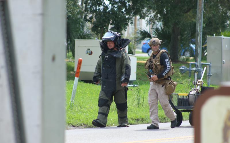 Bomb squad members head toward the Quality Inn to check on the suspicious device found Thursday morning. (JAMIE WACHTER/Lake City Reporter)