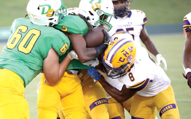 DeLand running back Ladamion Bletcher tries to power through Columbia defenders, including Markeyon Moore (8) on Friday night at Spec Martin Memorial Stadium. (BRENT KUYKENDALL/Lake City Reporter)