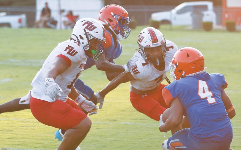 Fort White linebacker Lecosta Byrd (left) and defensive back Tafari Moe close in for a tackle against Jefferson County on Monday night. (MORGAN MCMULLEN/Lake City Reporter)
