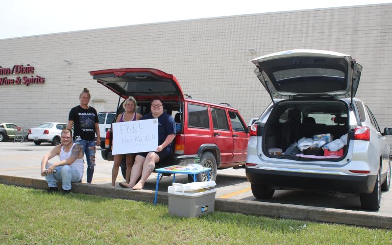 Curtis Handy, Jordana Smith, Daniels Cornuet and Haley Piercey gather outside Winn-Dixie on Friday where they were offering free hot meals to area residents following Hurricane Idalia. (TONY BRITT/Lake City Reporter)
