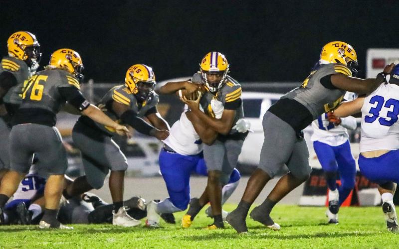 Columbia quarterback Zack Paulk tries to escape pressure from the Trinity Christian defense on Friday night. (BRENT KUYKENDALL/Lake City Reporter)