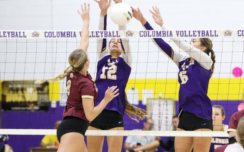 Columbia’s Kayla Goodloe (12) and Sinei Wood (6) attempt to block a shot by Oak Hall hitter Ave Scorpio on Tuesday night. (BRENT KUYKENDALL/Lake City Reporter)