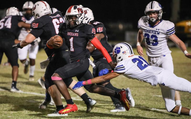 Fort White running back Dakota Fisher races past a Ridgeview defender on Friday.  (BRENT KUYKENDALL/Lake City Reporter)