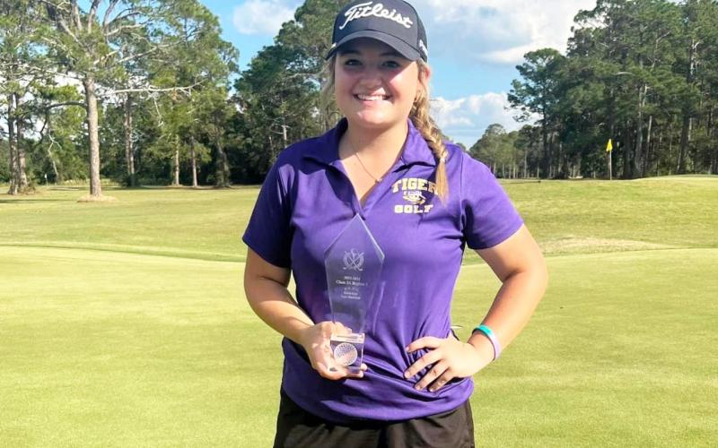 Columbia golfer Karlee Gainey poses with her Region 1-2A championship trophy on Tuesday. (COURTESY)