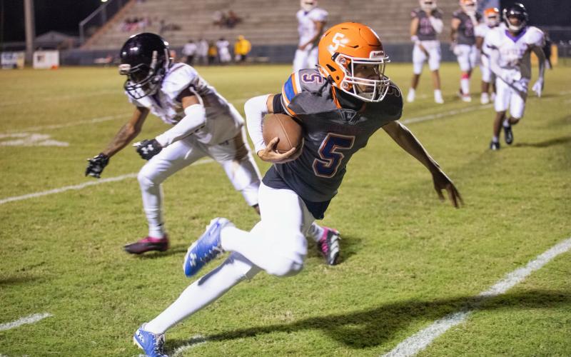 Branford receiver Kyshaun Veasey runs past a Hollis Christian Academy defender on Friday. (ERIN ROBERTS/Special to the Reporter)