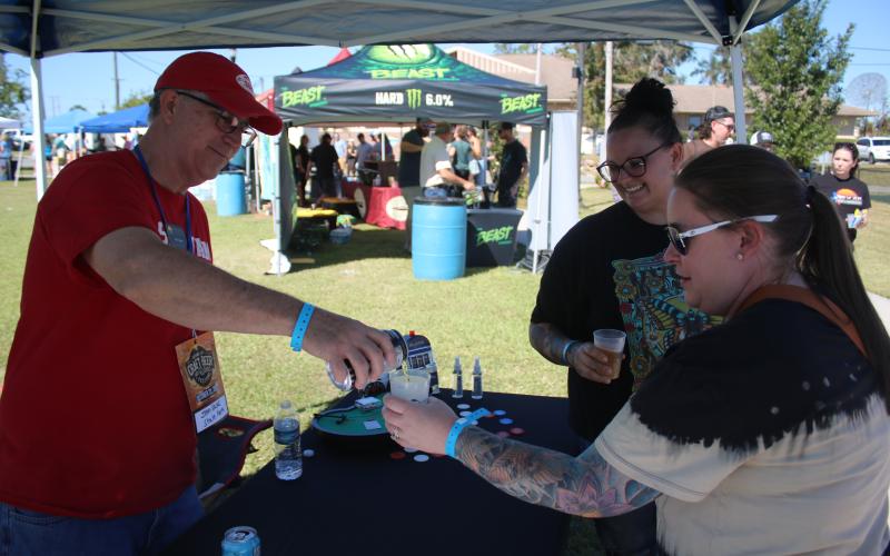 John Kasak (clockwise from left) pours cider for Gateway City Craft Beer and Wine Festival visitors Whitney Martin and Ashley James. (TONY BRITT/Lake City Reporter)