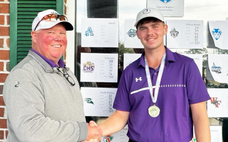 Columbia head coach Sherman Reed (left) shakes hands with Columbia golfer Connor Williams (right) after Williams won the Region 1-2A title on Tuesday. (COURTESY)