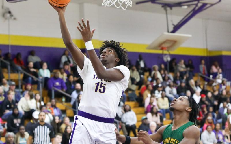 Columbia forward Zavian Douglas makes a layup ahead of Suwannee’s Ja’Darius Cherry on Tuesday. (BRENT KUYKENDALL/Lake City Reporter)