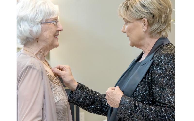 Tina Roberts (right) looks at Rose Pavey’s necklace at the Rotary Ball at The Blanche Hotel in January. Roberts is the co-chair of the Holidays with Haven event at The Blanche on Dec. 8. (LANCE BASS/Special to the Reporter)