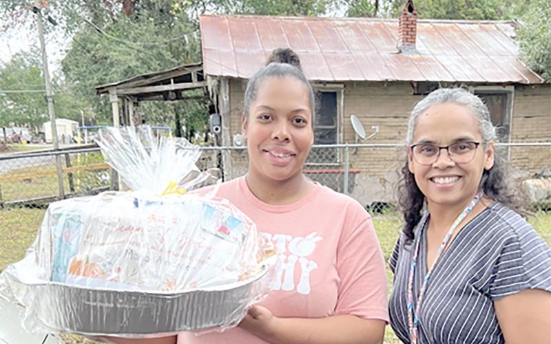 Nilda Soto, a family support specialist with the Early Learning Coalition of Florida’s Gateway, delivers a meal to Maria Alexander, a Season of Giving recipient, earlier this month. (COURTESY)