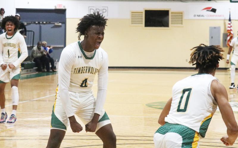 FGC forward Ty’jahn Wright (4) and guard Antewan Webber (1) celebrate after a dunk by Oakley Lewis (0) against Polk State College on Wednesday. (JORDAN KROEGER/Lake City Reporter)