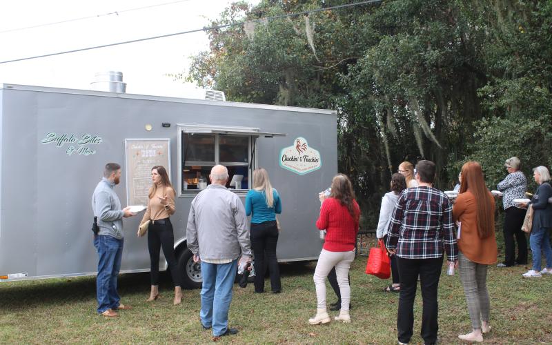 A line waits at the Cluckin’ and Truckin’ food truck at The Foundation for Florida Gateway College Giving Day campaign event Tuesday. (TONY BRITT/Lake City Reporter)