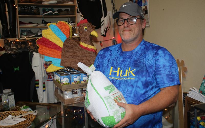 John ‘Lit’ Cole, the president of Kids Feeding Kids, holds one of the turkeys that the organization plans to give to families in need today. (TONY BRITT/Lake City Reporter)